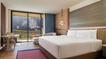 Une chambre d’hôtel dotée d’un grand lit, d’un balcon avec vue, d’un coin repas et d’un mur décoratif.