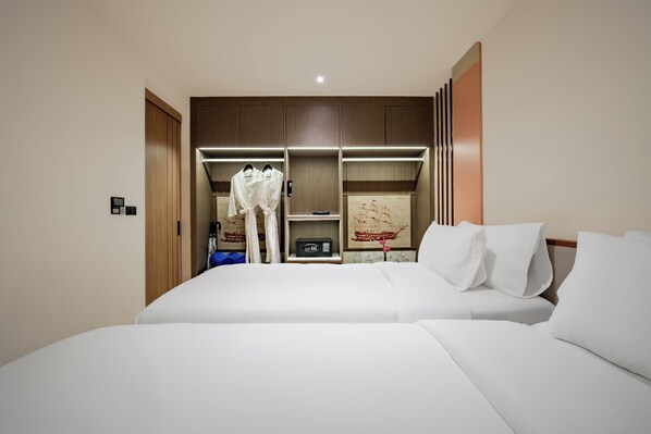 A hotel room with a large bed, a wardrobe, a small table, and a mirror.