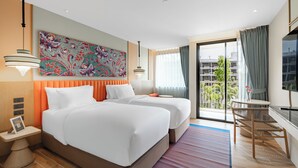 Une chambre d’hôtel avec deux lits, une grande fenêtre donnant sur un beau paysage, un bureau et une télévision.