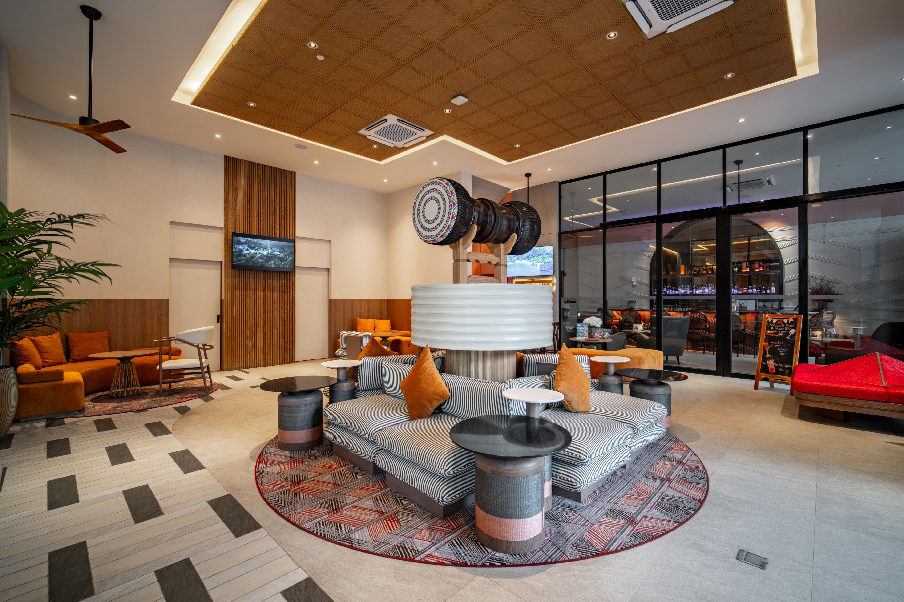 Een moderne lobby met een zithoek, een televisie en een bar.