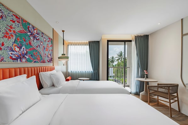 Habitación de hotel con dos camas, un balcón con vistas, una mesa redonda y una silla.