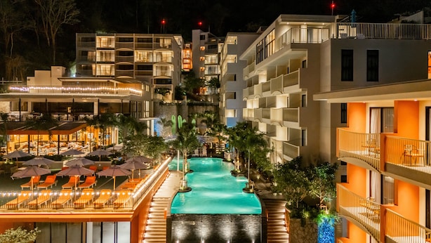 Ein Hotel mit Schwimmbad, mehreren Balkonen und Außenbereichen zum Sitzen.