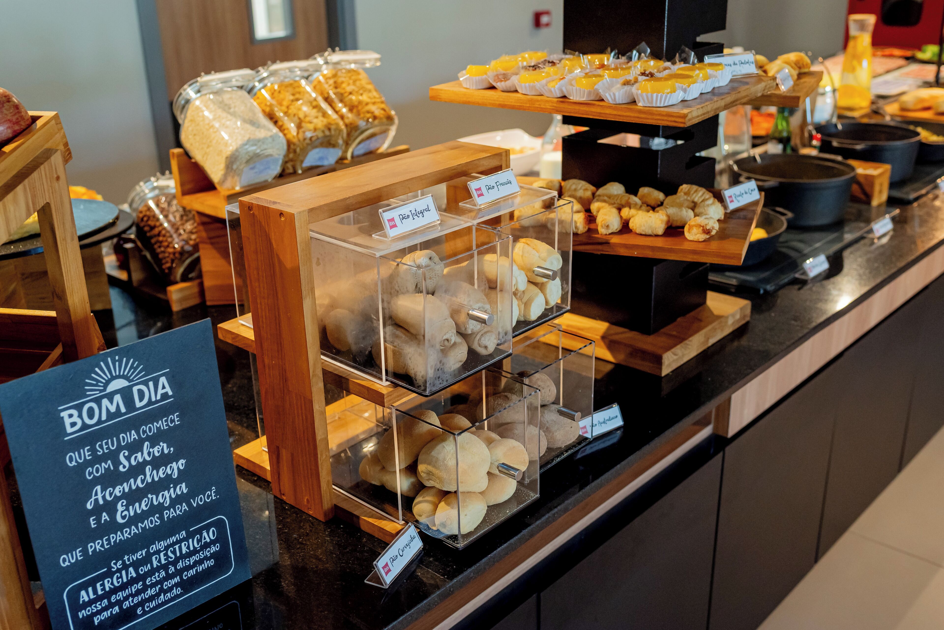 Un bufé de desayuno con diferentes opciones de comida y un cartel con un mensaje de salud.