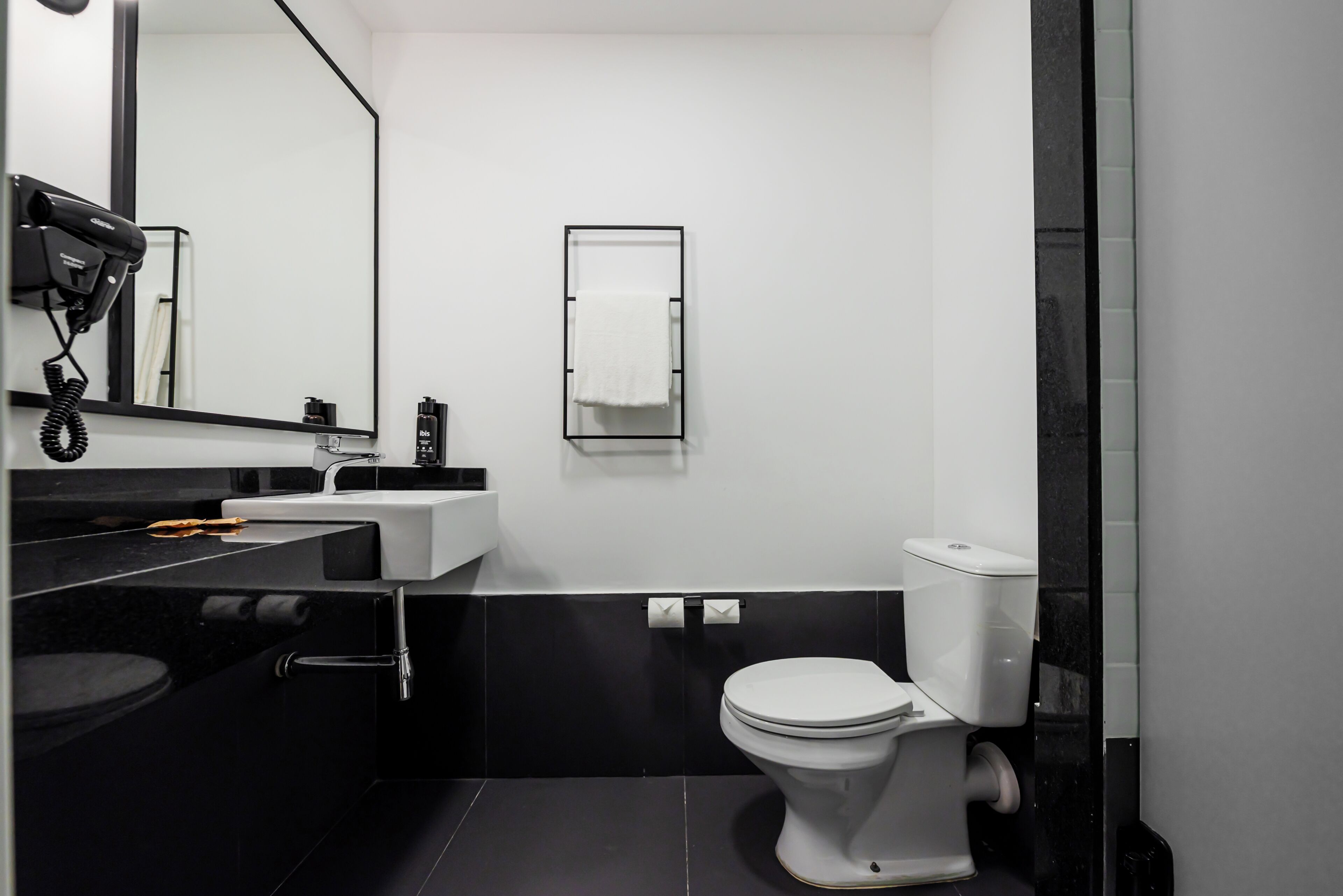Un baño moderno con inodoro, lavabo y espejo.