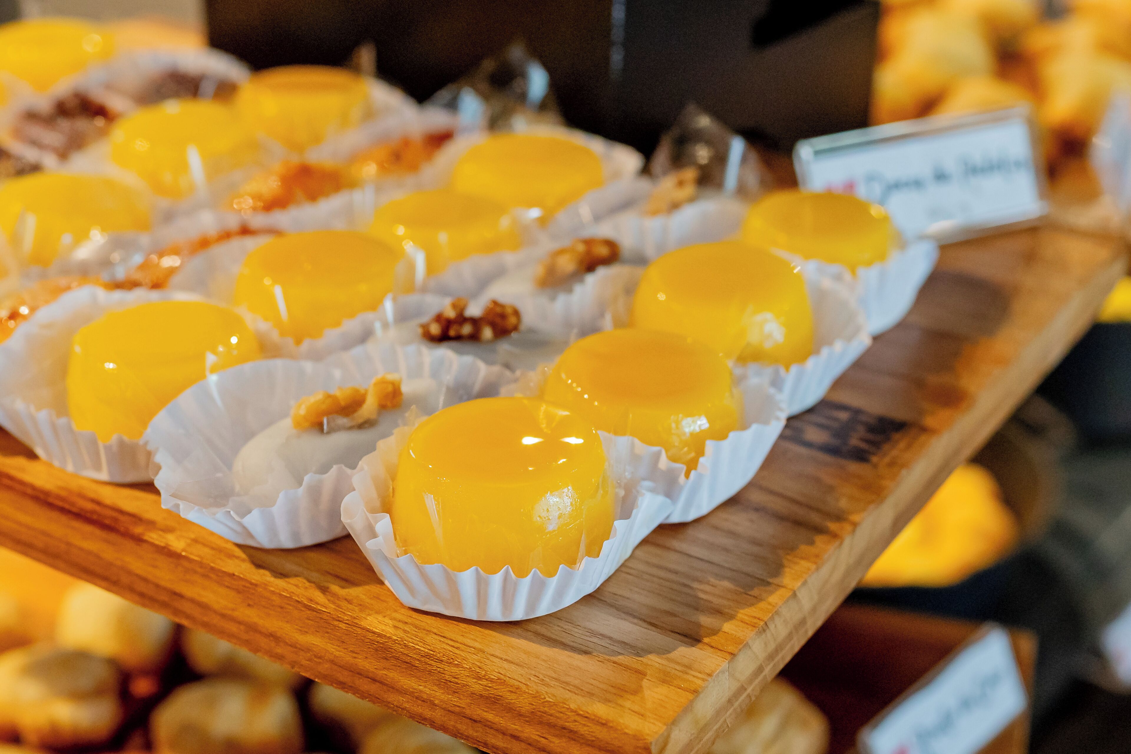 A display of yellow confections in paper cups.