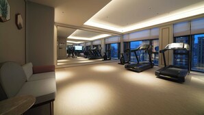 A hotel room with a treadmill, exercise equipment, a sofa, and a large mirror. - Mercure Hangzhou Gongshu Wanda Plaza (Hangzhou)
