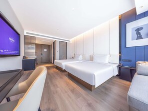 Ein modernes Hotelzimmer mit einem großen Bett, einem Schreibtisch und einem Fernseher.