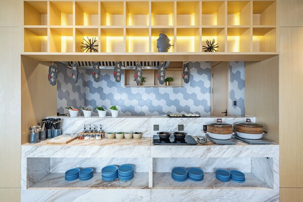 A modern kitchen with marble countertops, a variety of cookware, and a geometric backsplash. - Mercure Shanghai Pudong Zhangjiang Park (Shanghai)