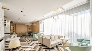 A modern living room with a sofa, chairs, a coffee table, and a patterned floor. - Mercure Shanghai Pudong Zhangjiang Park (Shanghai)
