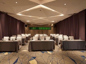 A conference room with tables and chairs, a patterned carpet, and a large screen on the wall. - Mercure Tai'An Centre (Tai'an)