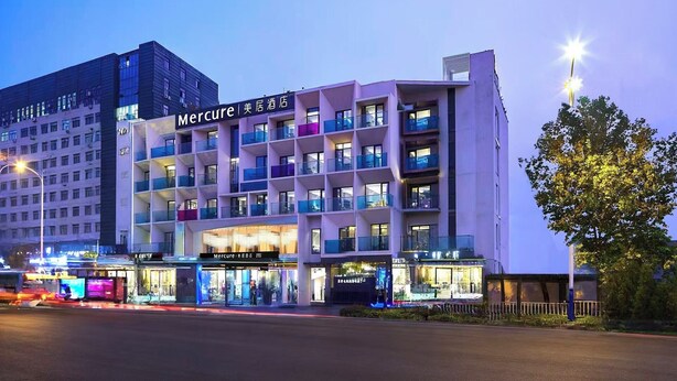 A multi-story hotel with a modern design, featuring balconies and a prominent entrance. - Mercure Tai'An Centre (Tai'an)