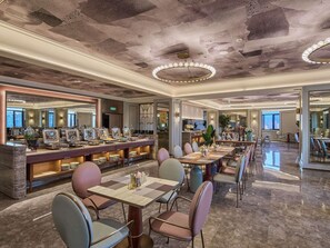 Un comedor amplio con barra libre, varias mesas y sillas.