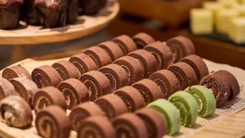 A display of chocolate rolls and other baked goods on wooden trays.