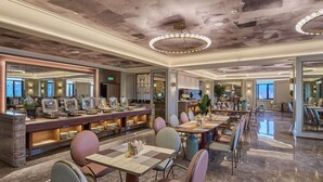 Un grand espace dédié à la salle à manger, avec un buffet, un mobilier moderne et une vue sur la ville.