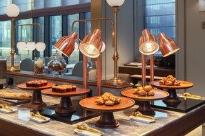 A buffet setup with copper serving lamps and a variety of pastries on wooden stands. - Mercure Xiamen Science City (Xiamen)