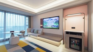 A modern living room with a large TV, seating area, and a fireplace. - Mercure Xiamen Science City (Xiamen)