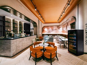 Un interior de restaurante moderno con barra, diferentes disposiciones de asientos y un refrigerador.