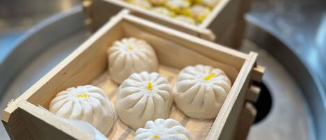 A tray with two wooden boxes containing white dumplings.