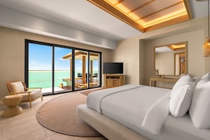 A modern bedroom with a large bed, a TV, a desk, and a view of the ocean. - Rixos Murjana - Ultra All Inclusive (Rabigh)