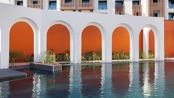 Un hôtel doté de nombreux balcons, d’une piscine et de passages voûtés.
