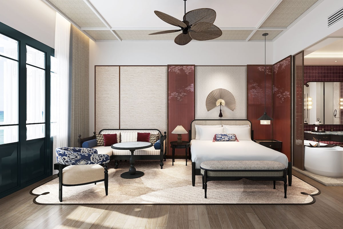 Une chambre d’hôtel moderne équipée d’un lit, d’un coin salon et d’une salle de bain.
