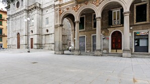 A historic building with arched doorways and a paved courtyard. - Apartment 'Mono' with Wi-Fi and Air Conditioning (La Spezia)
