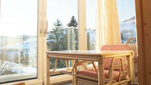 A room with large windows, a table, and two chairs. - Bergvital Hotel Todtnau (Todtnau)