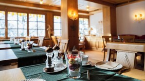 A dining area with tables set for service, clear windows, and wooden beams. - Bergvital Hotel Todtnau (Todtnau)