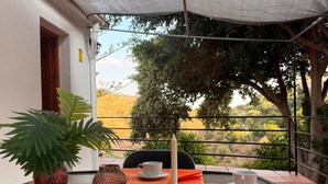 A table set for two with a view of a hillside.