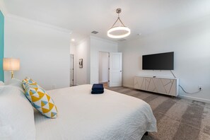 Een hotelkamer met een bed, een televisie, een deur en een vloerbedekking.