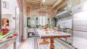 Una cocina con una isla grande, pared de ladrillo y salpicadero de azulejos.