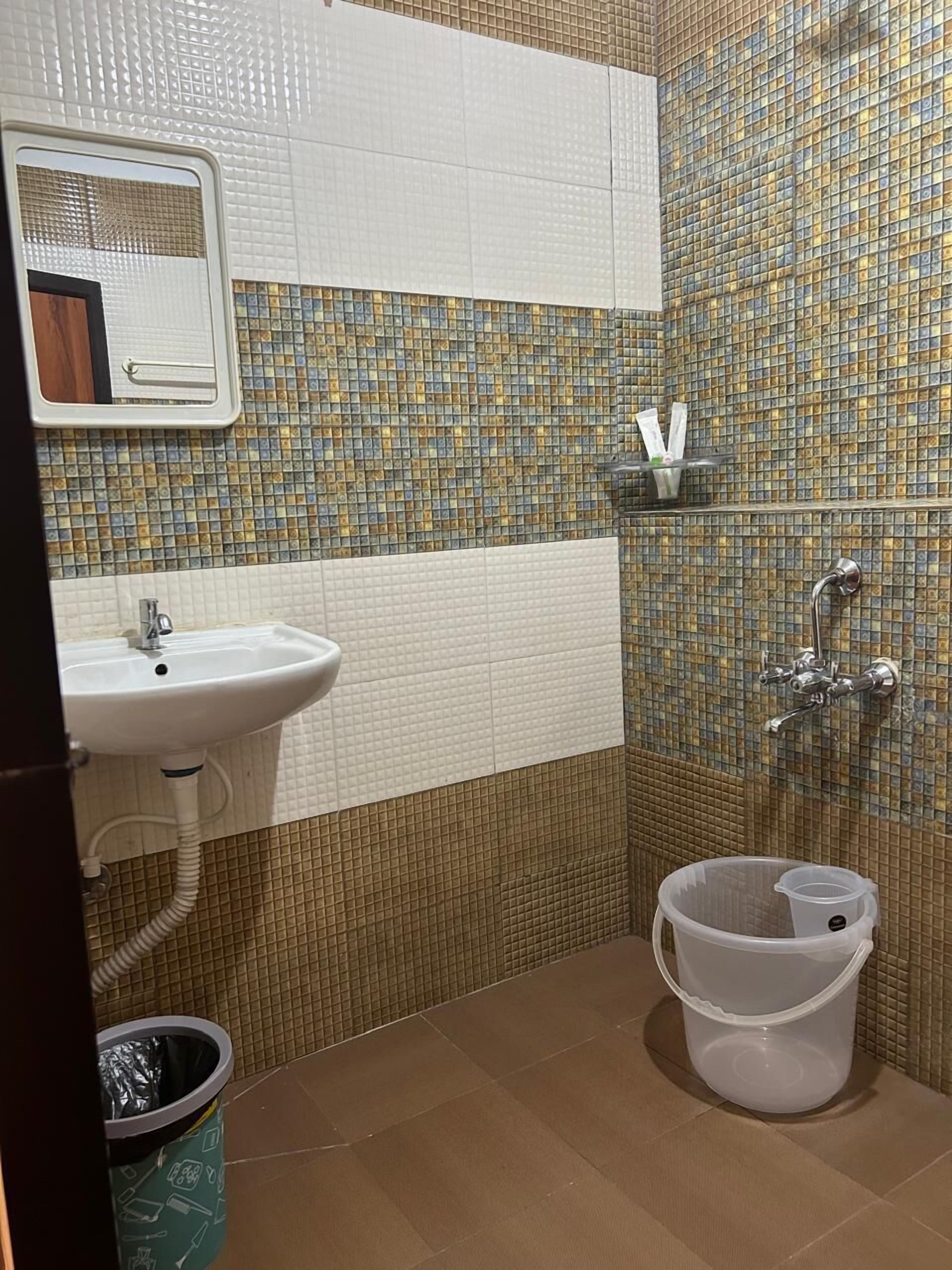 A bathroom with a sink, mirror, and shower.