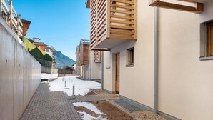 A narrow alleyway with buildings on either side, a paved walkway, and a snow-covered ground. - Apartment 'Villa Helena' with Mountain View, Private Terrace and Wi-Fi (Cavalese)