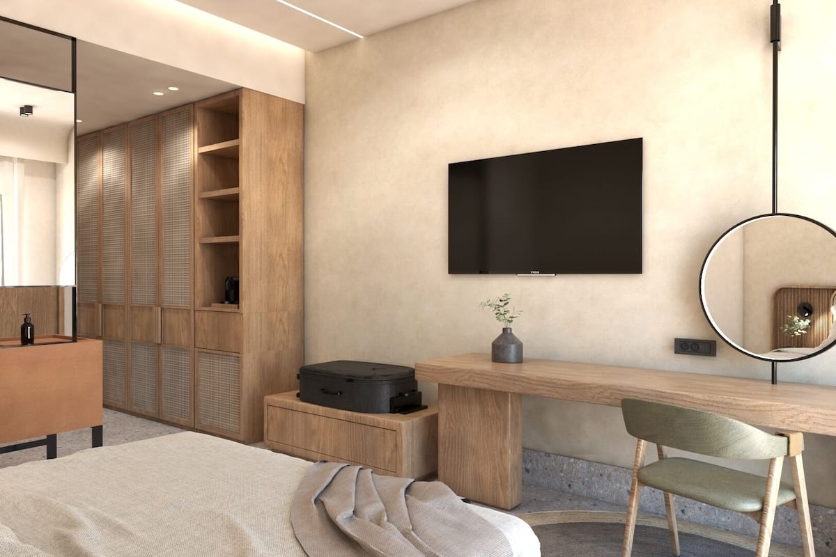 A modern bedroom with a bed, a wooden desk, a chair, a television, and a wardrobe.