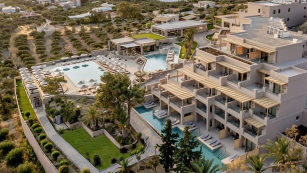 A modern hotel with multiple balconies, a swimming pool, and landscaped gardens. - Kakkos Terra Blu (Ierapetra)