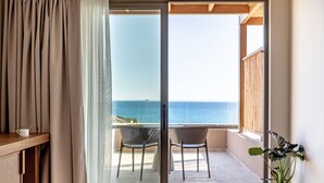 A balcony with a view of the sea, a table with a cup, and a potted plant. - Kakkos Terra Blu (Ierapetra)