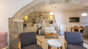 A cozy living area with stone walls, a sofa, armchairs, a coffee table, and a dining table. - Traditional Villa w/ Pool & BBQ, near Rethymno (Atsipades)