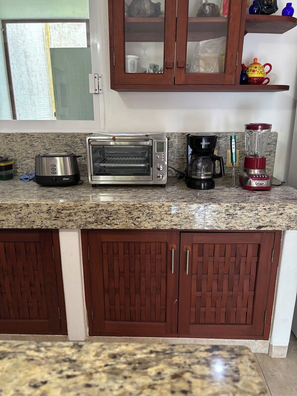 A kitchen with a toaster, coffee maker, and blender on the counter.