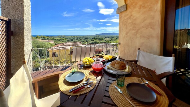 Ein Balkon mit Frühstückstisch, der auf eine reizvolle Landschaft blickt.