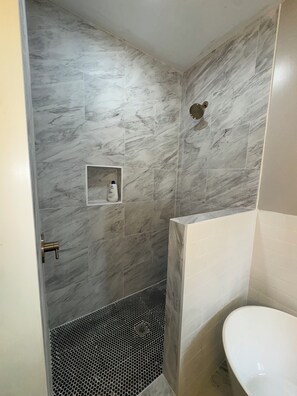 Een douche, handdoeken, zeep, toiletpapier