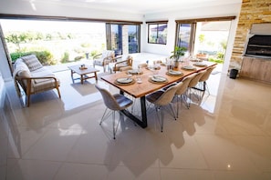 A spacious dining area with a large wooden table set for six, surrounded by modern chairs.