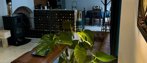 Una sala de estar con chimenea, un comedor y una planta grande.