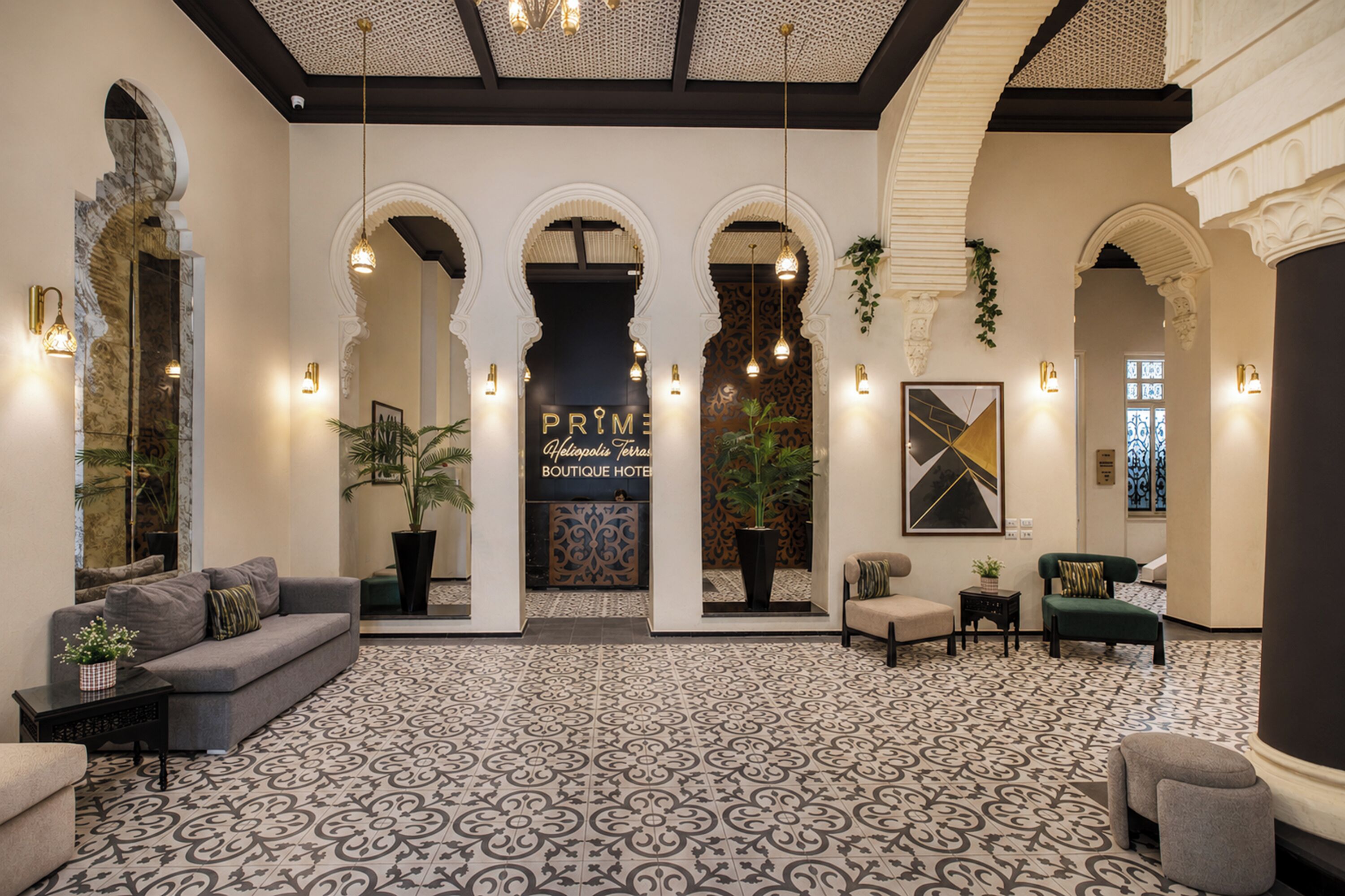 A lobby with a patterned floor, sofas, a coffee table, and a reception desk.