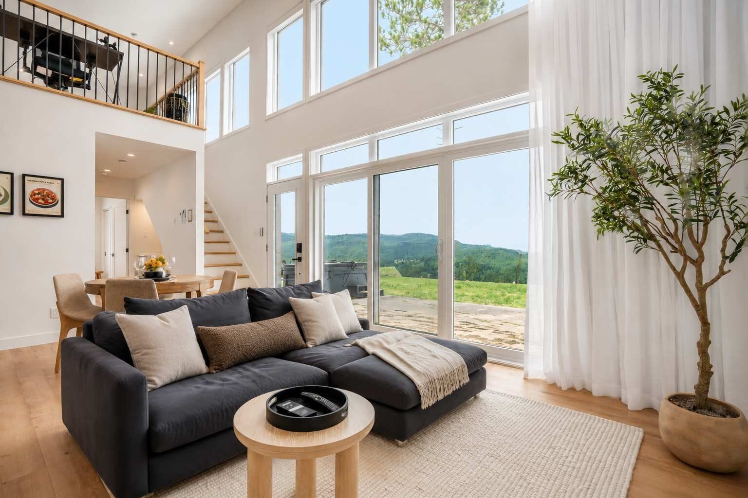Un moderno salón con un sofá modular, una mesita redonda y un amplio ventanal con vistas al exterior.