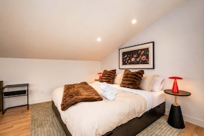 A bedroom with a bed, pillows, a bedside table, a lamp, and a picture on the wall. - Modern Comfort | SPA | Mountain | Chalet KNOX (Saint-Côme)
