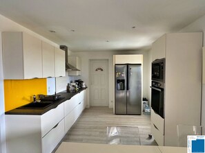 A modern kitchen with white cabinets, a stainless steel refrigerator, a built-in oven, and a microwave. - VILLA GIULIA - 4 BEDROOMS - SWIMMING POOL - JACUZZI (Porto-Vecchio)