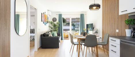 A modern kitchen with a dining area, a large mirror, and a view to the outside.