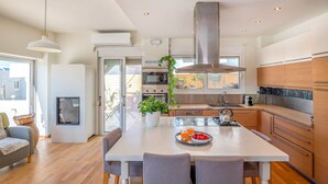 Una cocina moderna con una isla central, electrodomésticos de acero inoxidable y un amplio ventanal.