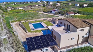 Ein Wohnhaus mit Swimmingpool, Solaranlage und Meerblick.