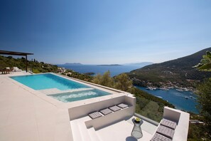 Une piscine à débordement située sur le toit, offrant une vue sur la mer et les montagnes.